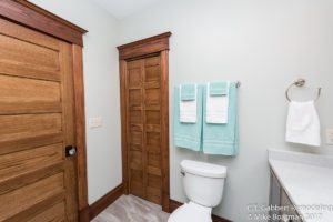plank flooring with pop of teal colored hand towels in remodeled bathroom