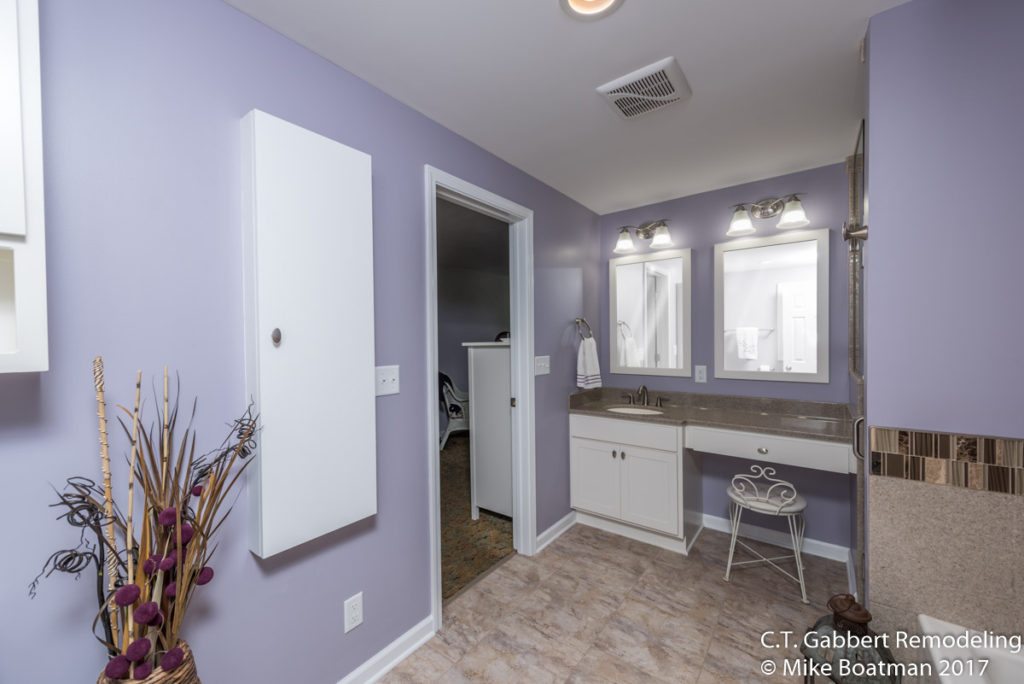 wall mounted cabinet for ironing board in purple bathroom suite