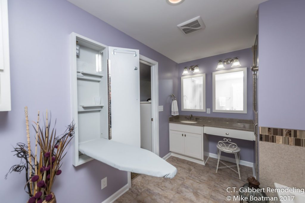 pull down ironing board in light purple bathroom