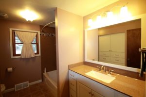 warm colors and onyx integrated rectangular sink in remodeled bathroom