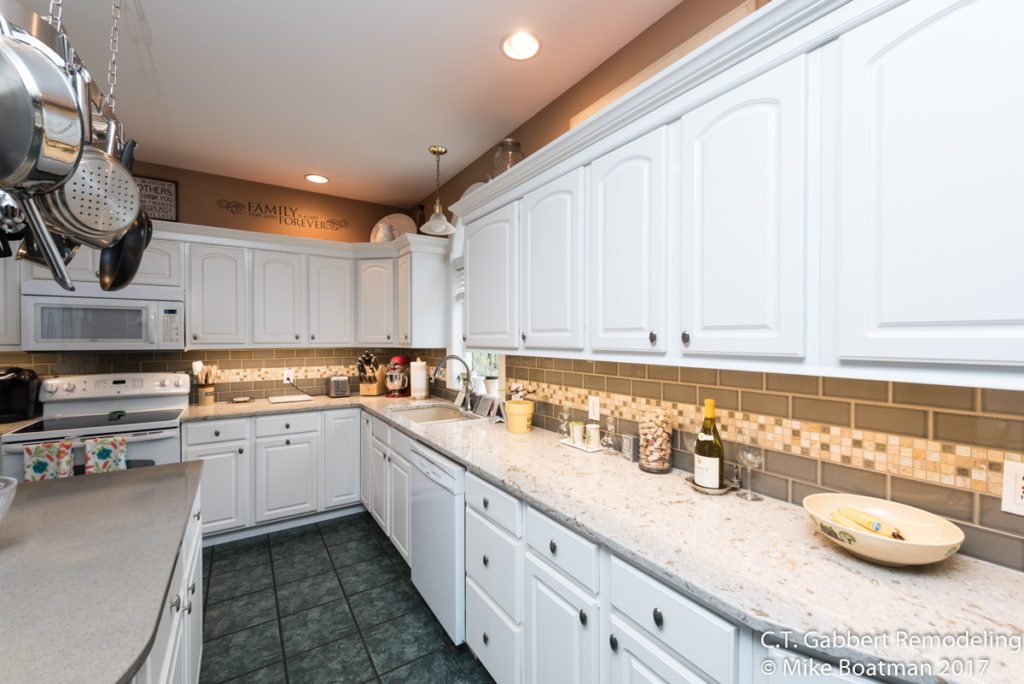 white kitchen cabinets with brushed nickel hardware and green flooring