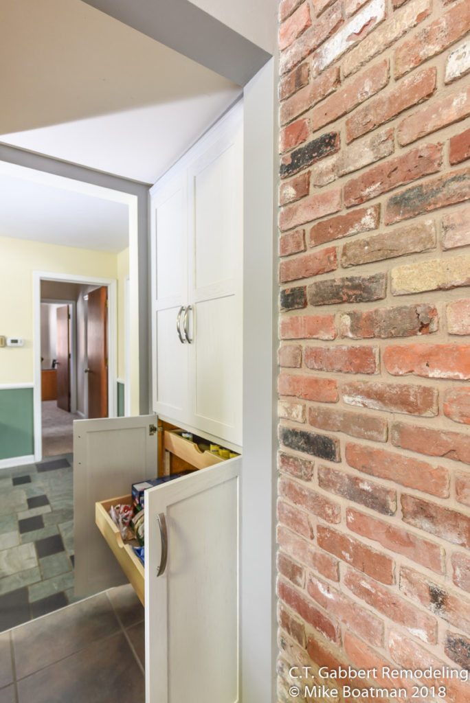 easy access storage with roll out trays near exposed brick wall