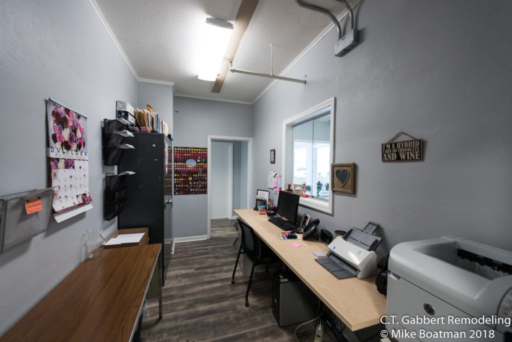 remodeled reception office with plank flooring and blue gray walls