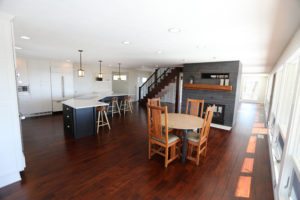 spacious open kitchen and dining room with wood floors and black and white accents