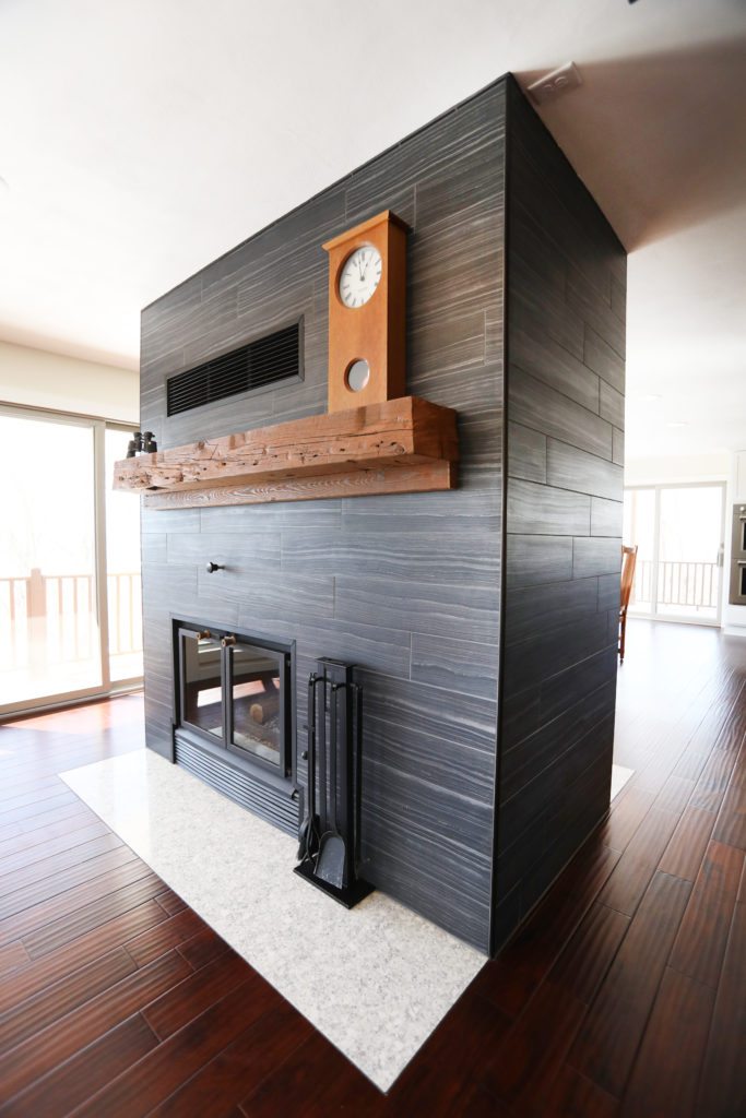 modern black fireplace with reclaimed wood mantle
