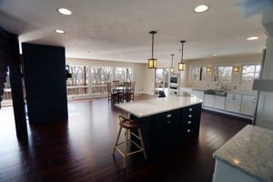 open kitchen with floor to ceiling windows and black marble island