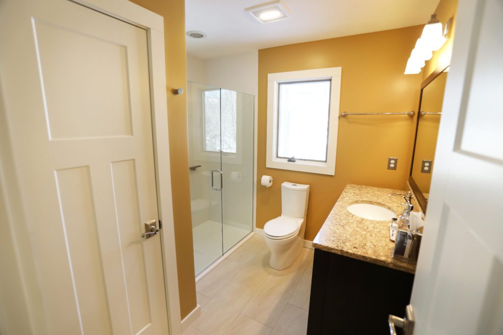 bathroom remodled with golden yellow paint and walk in shower