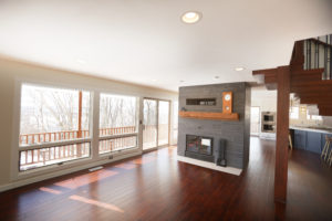 open living room with floor to ceiling windows and black and brown fireplace