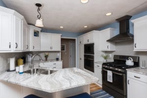 white marble island with wood flooring in kitchen remodel