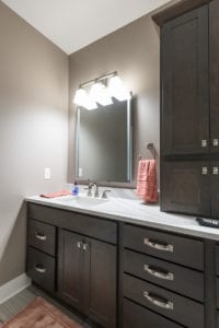 new lighting over his and her sinks with rich brown cabinents
