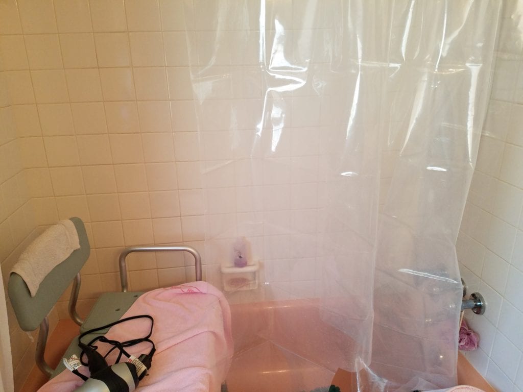 accessible bathroom with pink towels before bathroom remodel