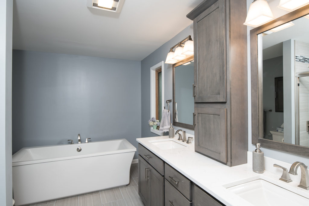 light grey showplace cabinets with lighting in remodeled bathroom
